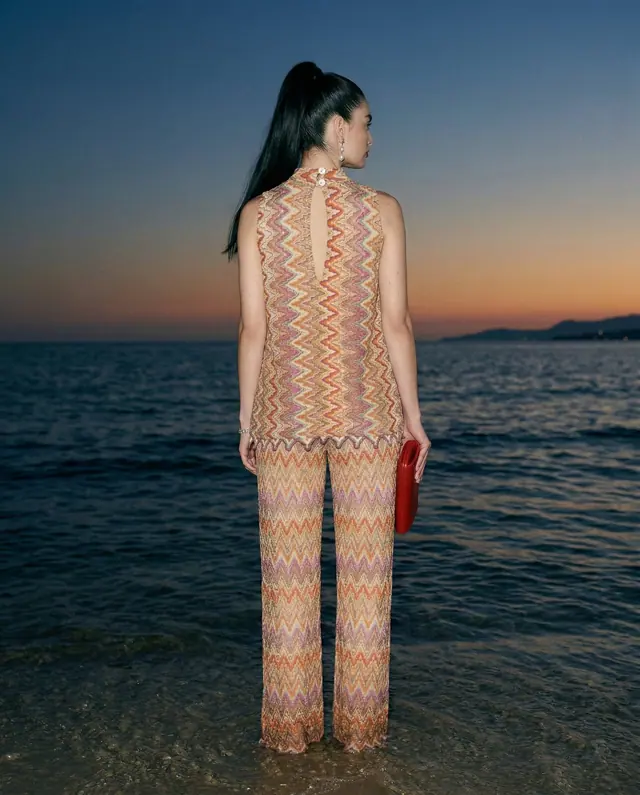 AI-generated model seen from behind in a zigzag knit set at sunset