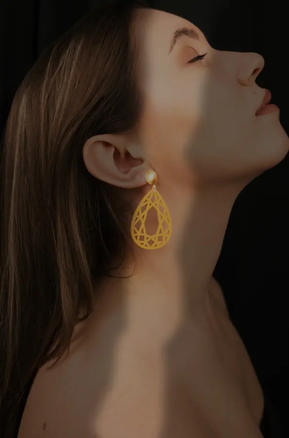 Profile portrait wearing gold filigree drop earrings