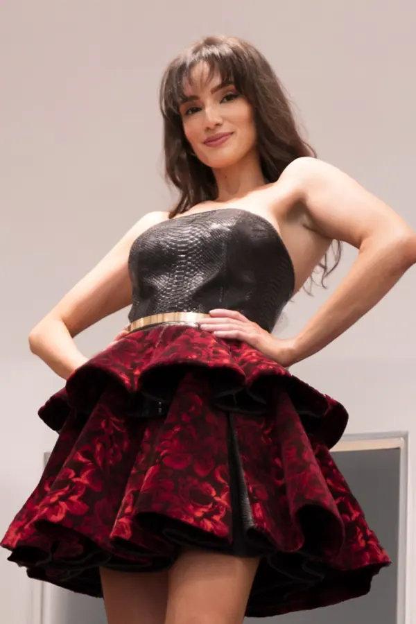 Model in a leather bustier and red jacquard skirt